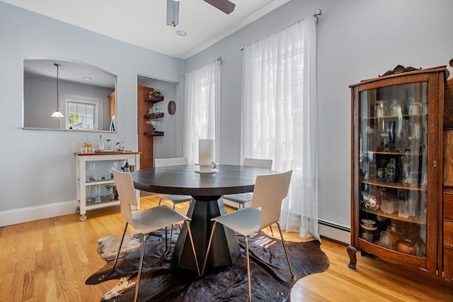 37 Devereux St, Marblehead, MA 01945 - dining space with a baseboard heating unit, ceiling fan, light wood-style flooring, crown molding, and arched walkways