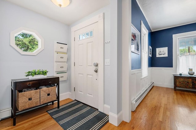 37 Devereux St, Marblehead, MA 01945 - entrance foyer with baseboard heating, light wood-style floors, and a wainscoted wall