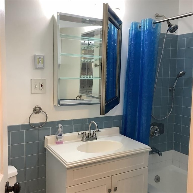 bathroom featuring vanity, shower / bath combination with curtain, and tile walls