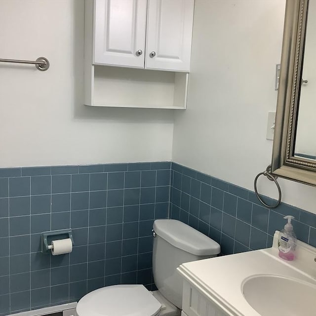 bathroom with vanity, a baseboard heating unit, tile walls, and toilet