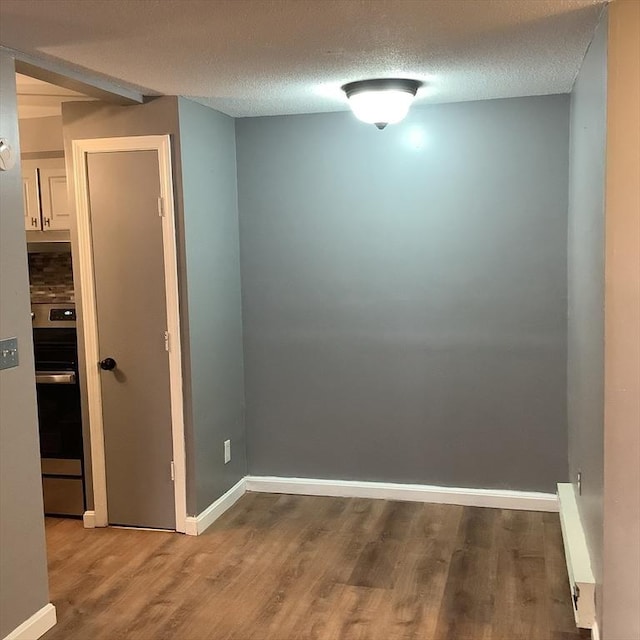 unfurnished room with hardwood / wood-style floors and a textured ceiling