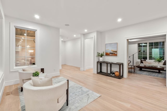 living area featuring baseboards, light wood-type flooring, visible vents, and recessed lighting