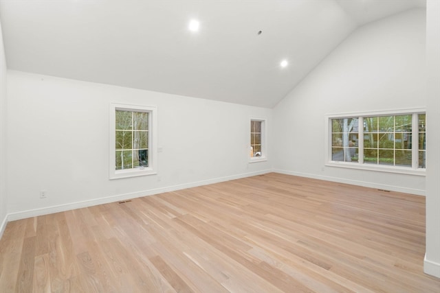 empty room featuring baseboards, light wood finished floors, and a healthy amount of sunlight