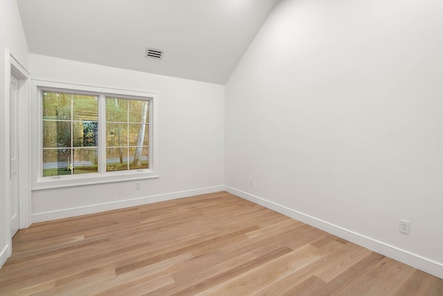 spare room featuring light wood-style floors, visible vents, and baseboards