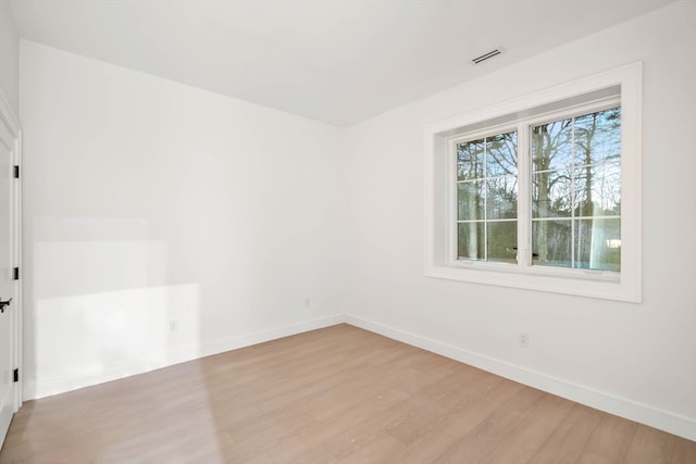 empty room featuring baseboards, visible vents, and light wood-style floors