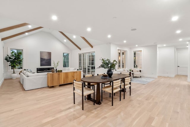 dining space with high vaulted ceiling, light wood-style flooring, and recessed lighting