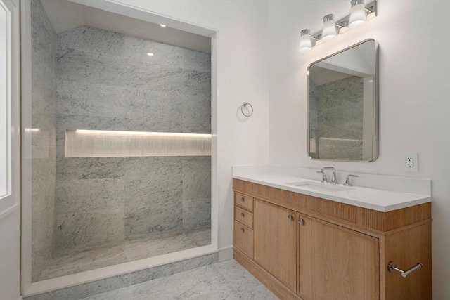 bathroom with marble finish floor, walk in shower, and vanity