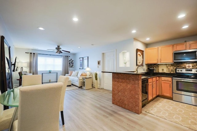 211 Central St Unit A305, Norwood, MA 02062 - kitchen with stainless steel appliances, dark countertops, open floor plan, backsplash, and light wood finished floors