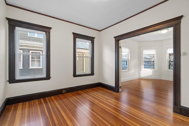 unfurnished room with plenty of natural light, dark hardwood / wood-style flooring, and crown molding