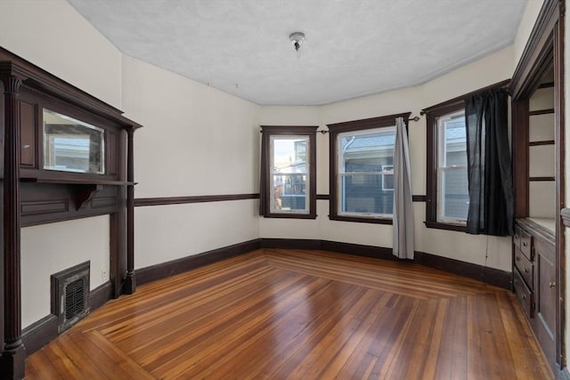 spare room with dark hardwood / wood-style floors and a wealth of natural light