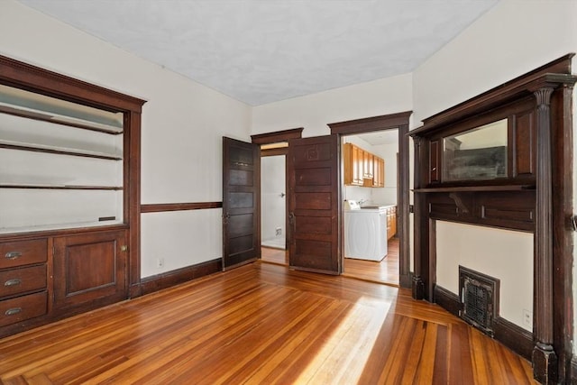 unfurnished living room featuring hardwood / wood-style floors and washer / clothes dryer