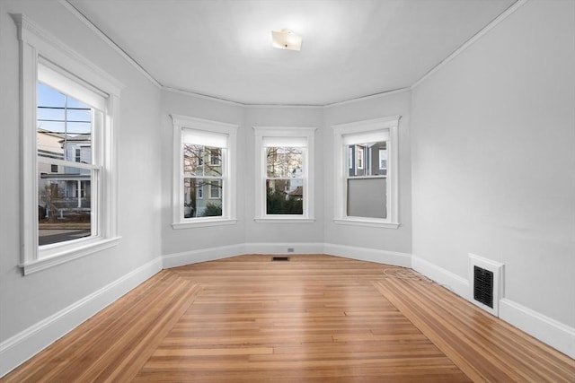 unfurnished room with crown molding and hardwood / wood-style floors