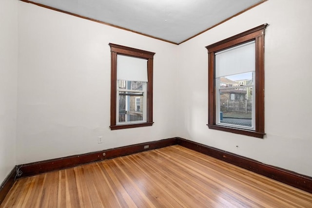 empty room featuring crown molding and wood-type flooring