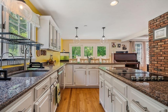 25 Brandt Beach Ave, Mattapoisett, MA 02739 - kitchen with dishwasher, white cabinets, healthy amount of natural light, black electric cooktop, and brick wall