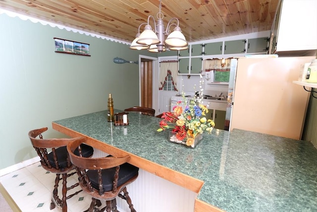 14 Cormack Rd, Sturbridge, MA 01566 - kitchen with wood ceiling, a chandelier, a kitchen breakfast bar, freestanding refrigerator, and washer / clothes dryer