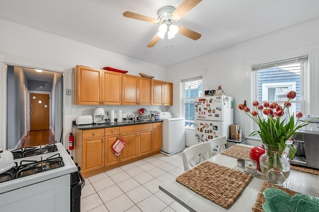 21 Sudan St, Boston, MA 02125 - kitchen with washer / clothes dryer, range with gas cooktop, freestanding refrigerator, a sink, and plenty of natural light