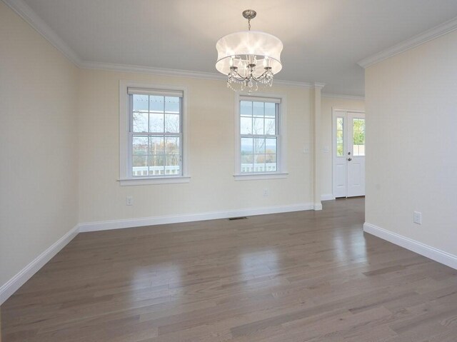 spare room featuring baseboards, visible vents, ornamental molding, and dark wood-type flooring