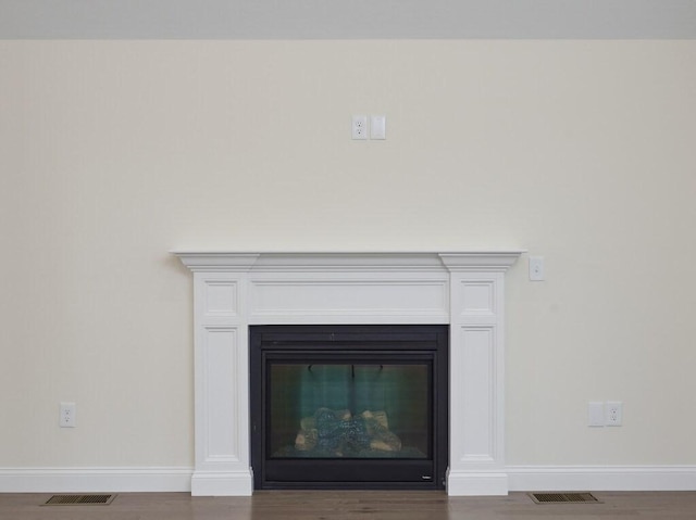 interior details featuring baseboards, visible vents, and a glass covered fireplace