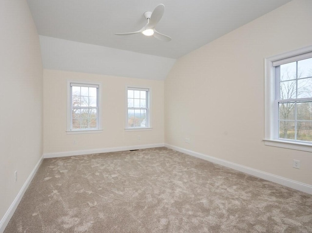 unfurnished room with light carpet, vaulted ceiling, and baseboards