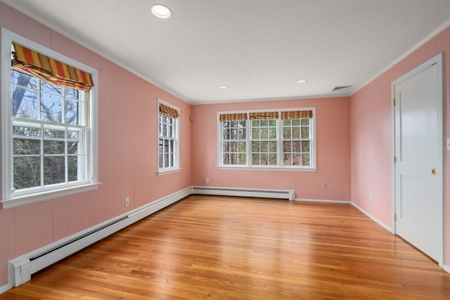 spare room with plenty of natural light, ornamental molding, light wood finished floors, and a baseboard radiator
