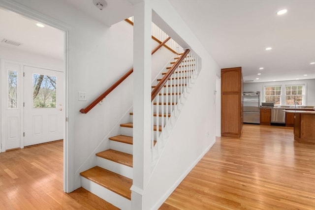 stairs with visible vents, recessed lighting, baseboards, and wood finished floors