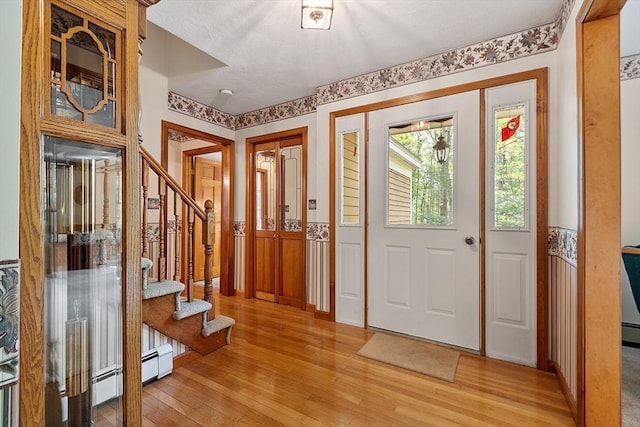 4 Clarke Rd, Littleton, MA 01460 - entryway featuring light wood-type flooring, stairway, wainscoting, and a baseboard heating unit