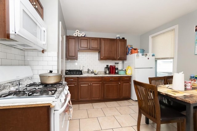 kitchen featuring decorative backsplash, white appliances, sink, and light tile patterned floors