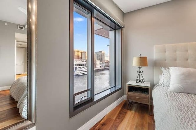 bedroom with access to exterior, baseboards, and wood finished floors