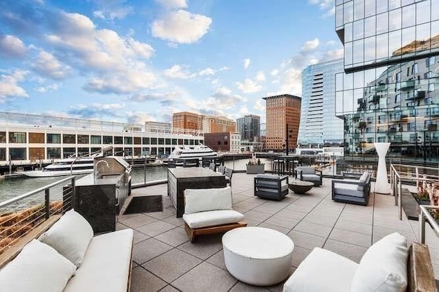 view of patio featuring outdoor lounge area, a city view, and a water view