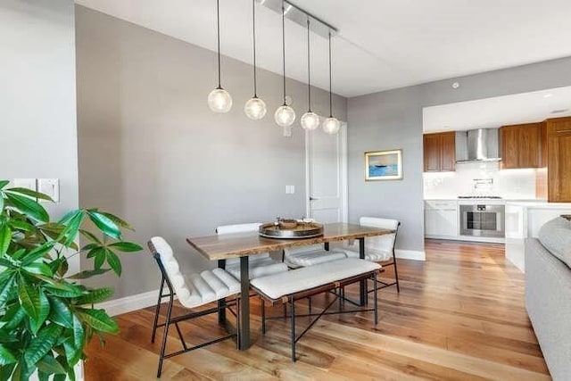 dining room featuring baseboards and light wood-type flooring