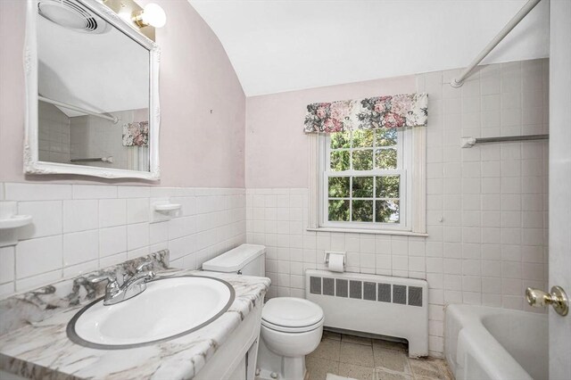 146 Elm St, Andover, MA 01810 - full bathroom featuring radiator, tile walls, lofted ceiling, vanity, and toilet