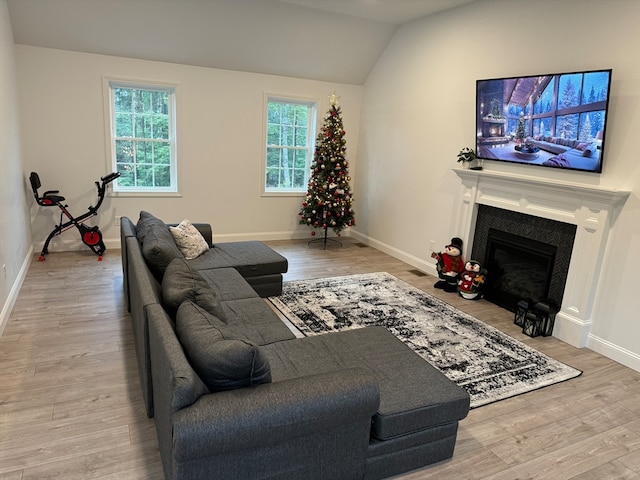 living room featuring light hardwood / wood-style floors, vaulted ceiling, and a wealth of natural light