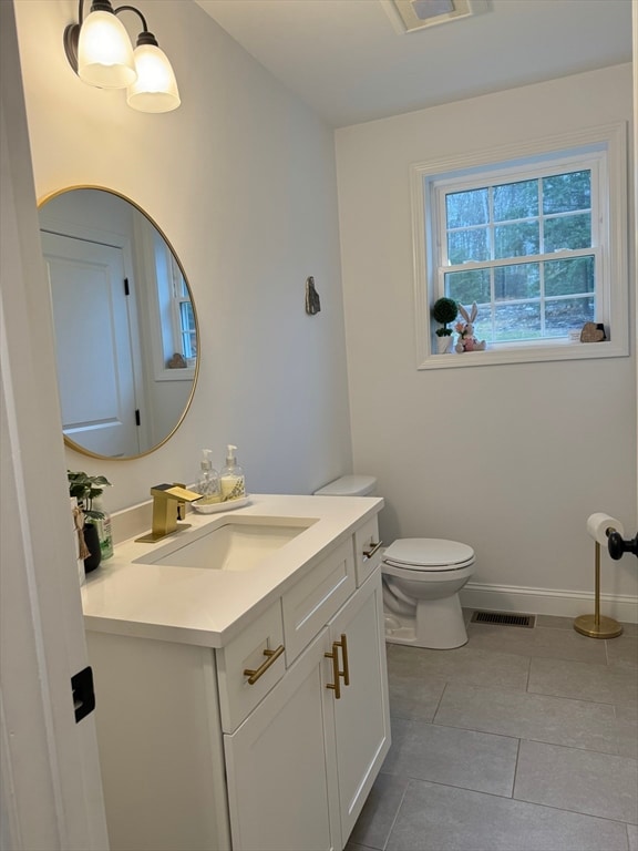 bathroom with tile patterned flooring, vanity, and toilet