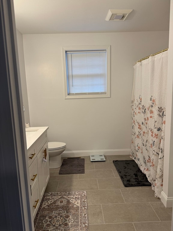 bathroom featuring tile patterned flooring, vanity, and toilet