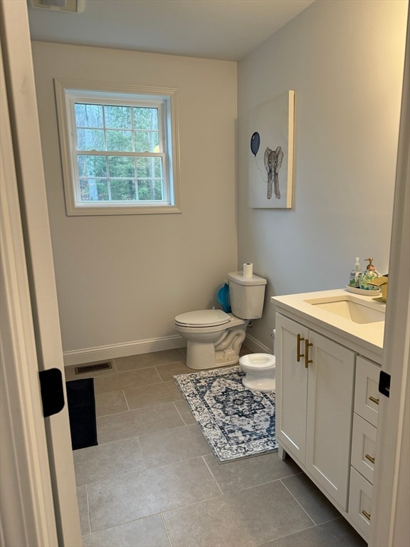 bathroom with tile patterned flooring, vanity, and toilet