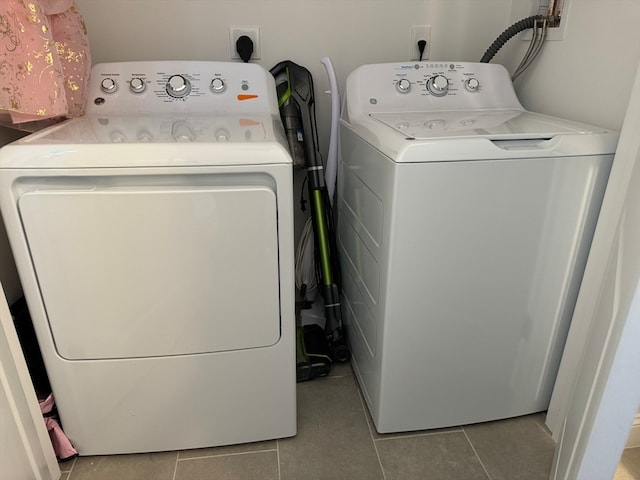 laundry area featuring washer and dryer and light tile patterned floors