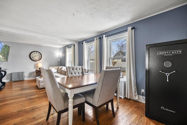 dining space featuring radiator heating unit and hardwood / wood-style floors