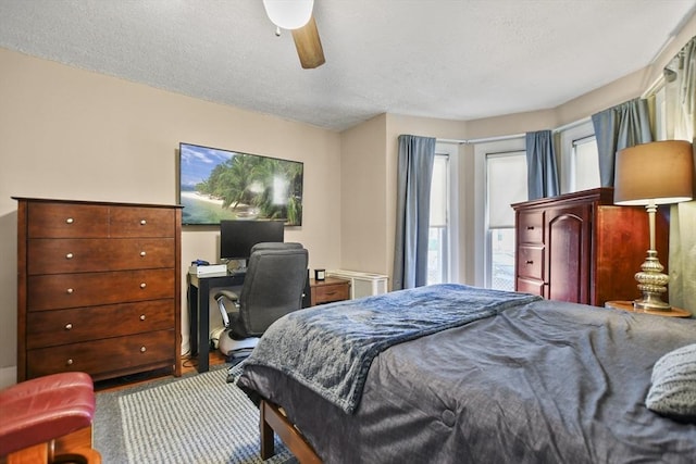 bedroom with ceiling fan and a textured ceiling