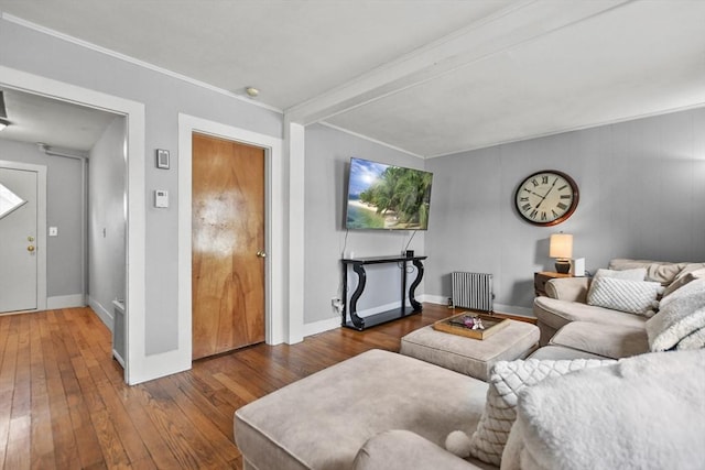 living room with beam ceiling, dark hardwood / wood-style flooring, and radiator heating unit