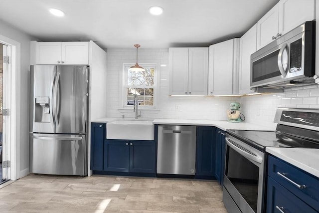 kitchen with sink, blue cabinets, white cabinetry, and appliances with stainless steel finishes