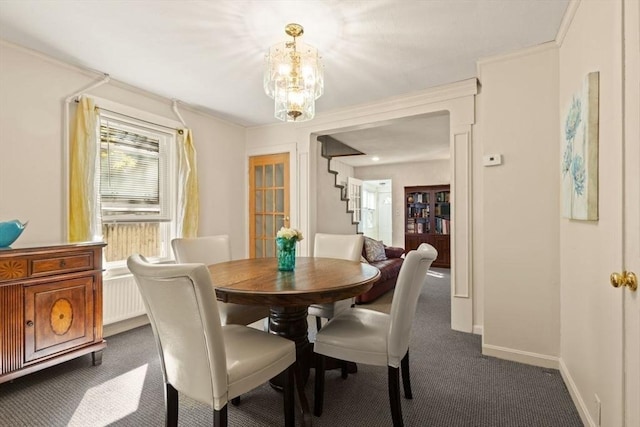 dining area featuring dark carpet, stairway, an inviting chandelier, and baseboards