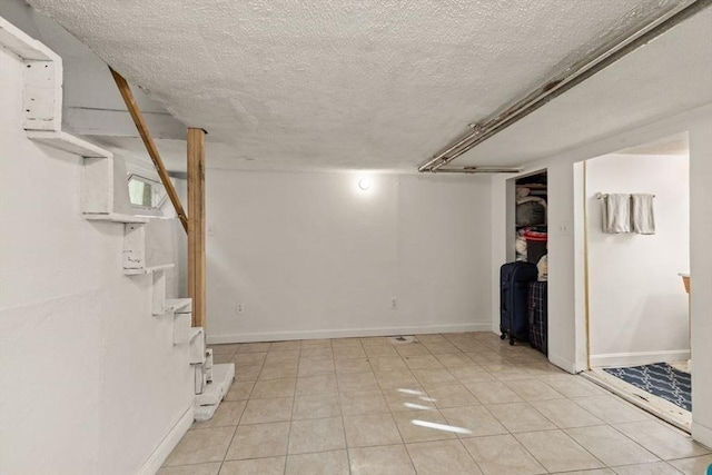 finished below grade area with baseboards and a textured ceiling