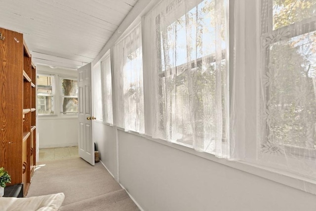 hallway featuring carpet floors and baseboards