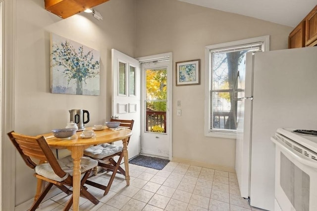 interior space with lofted ceiling, light tile patterned floors, and baseboards