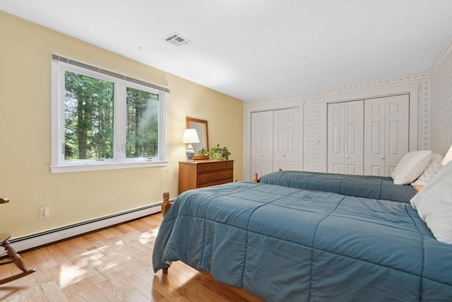 187 Middle Rd, Southborough, MA 01772 - bedroom featuring baseboard heating, multiple closets, wood finished floors, and wallpapered walls