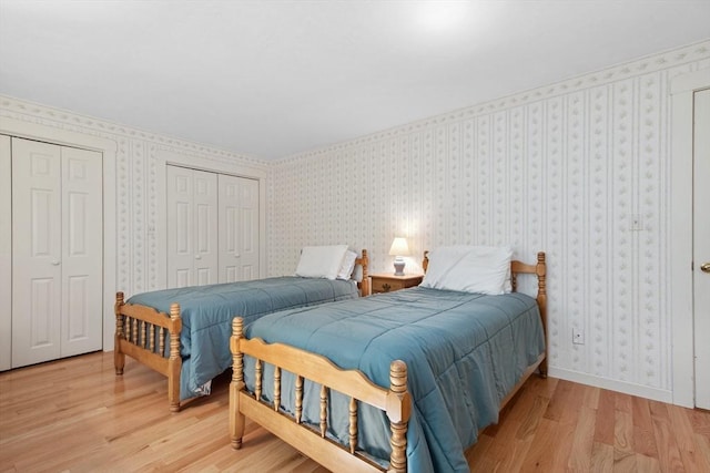 187 Middle Rd, Southborough, MA 01772 - bedroom with light wood finished floors, two closets, and wallpapered walls