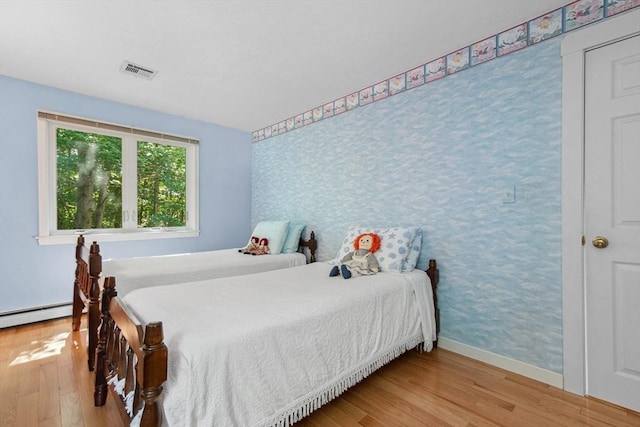 187 Middle Rd, Southborough, MA 01772 - bedroom featuring wood finished floors, baseboards, a baseboard heating unit, and wallpapered walls