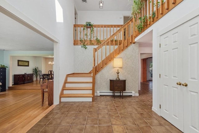 187 Middle Rd, Southborough, MA 01772 - stairway with baseboard heating, a towering ceiling, and a chandelier