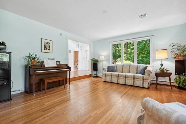 187 Middle Rd, Southborough, MA 01772 - living room featuring baseboard heating, light wood-type flooring, and a chandelier