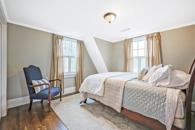 bedroom featuring multiple windows, dark wood-type flooring, baseboards, and ornamental molding